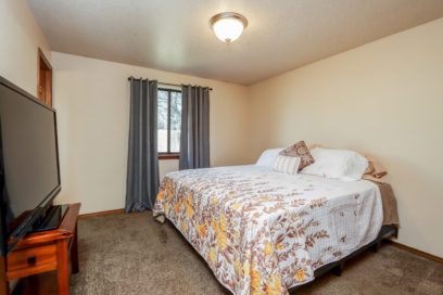 Master bedroom with bed and view of TV